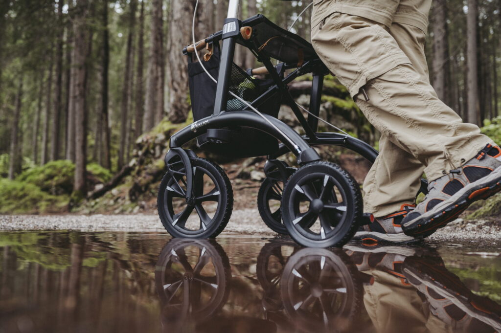 Detalj bilde av Saljol Allrounder Rollator som ruller i en sølepytt