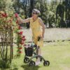 Dame med Saljol Carbon Rollator ser på blomster
