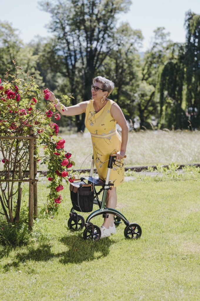 Dame med Saljol Carbon Rollator ser på blomster