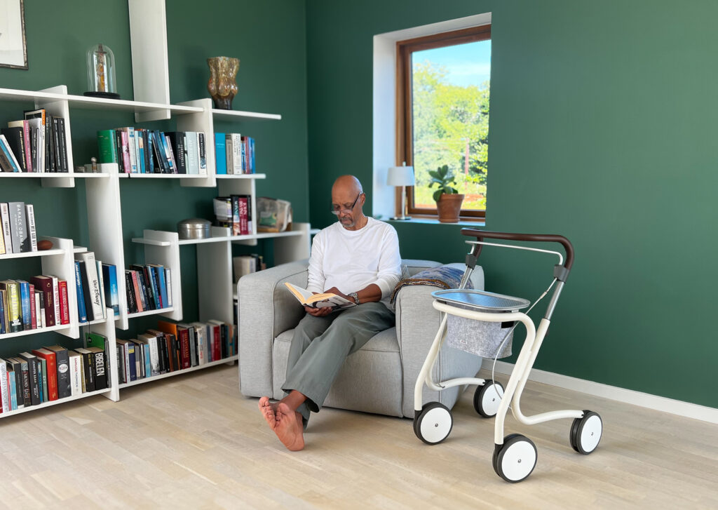 Mann sitter i stol med Scandinavian Butler ved siden av